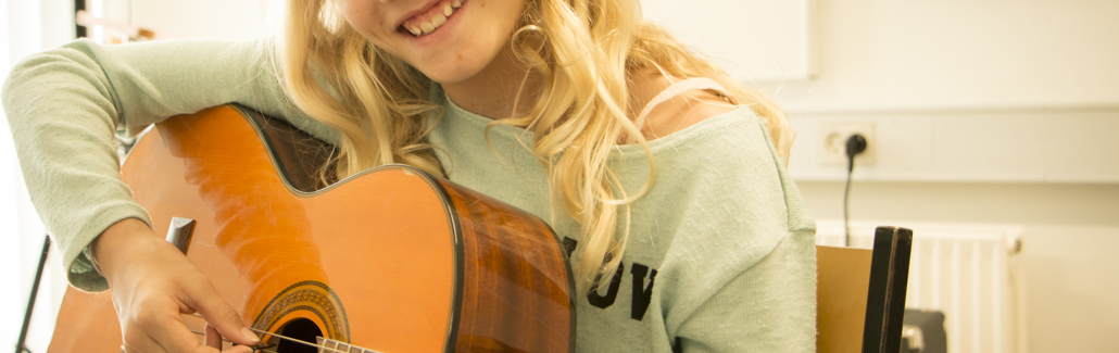 Glad pige på akustisk guitar